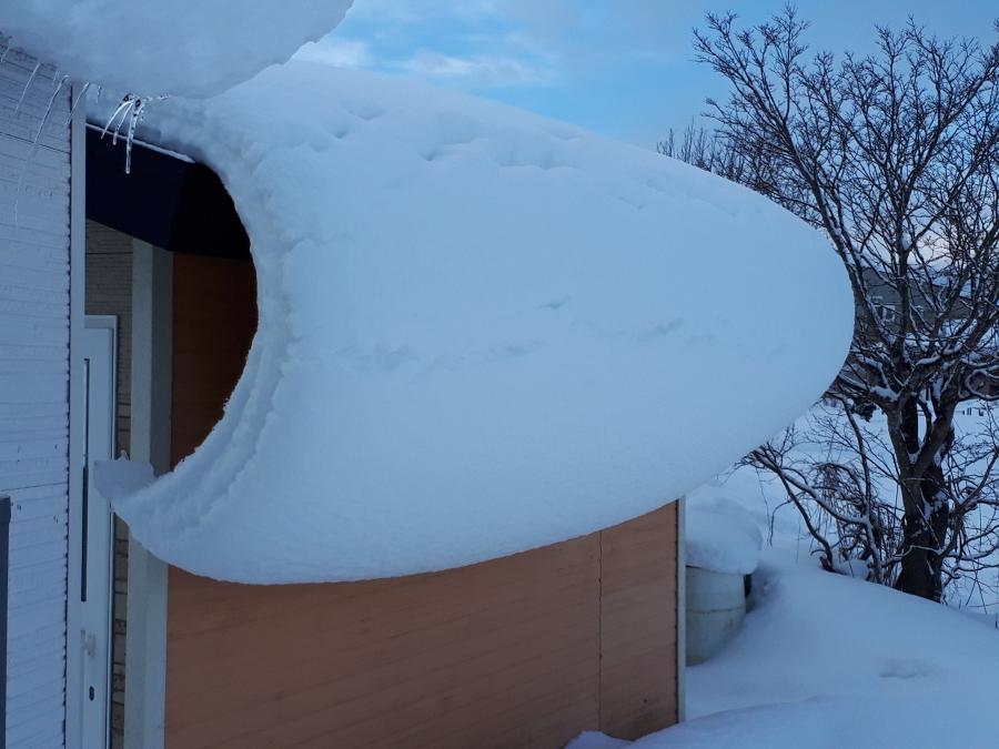 軒先からせり出す雪